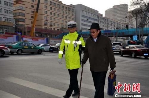 兰州交警扶老人过马路。　李悦郡 摄