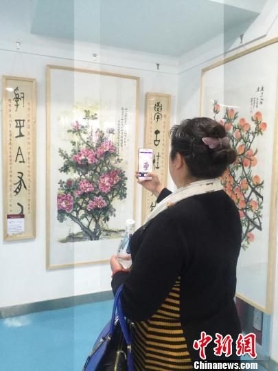 图为游客欣赏河州牡丹画作。　崔琳 摄
