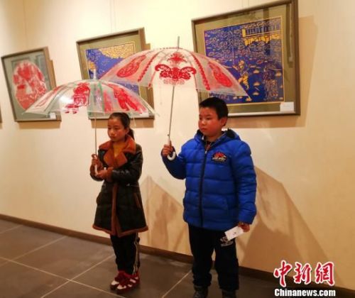 图为黏贴在雨伞上的剪纸作品展示。　崔琳 摄