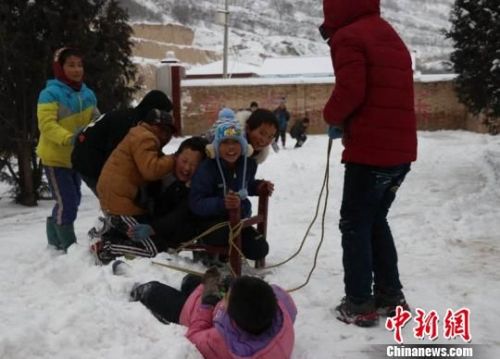 　　瓦天沟小学老师仿佛回到自己的孩童时光，图为老师和小学生们在课间痛痛快快得玩雪。　敬斐斐 摄 