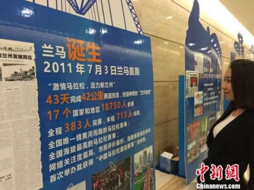 当天发布会现场摆放展板回顾了7年“兰马”对兰州城市发展与全民健身发展的带动作用。图为民众观看马拉松展板了解“兰马”。　史静静 摄