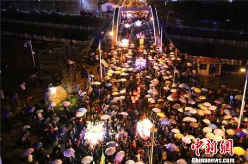 3月6日，正月十九，天空下起小雨，数万民众撑起雨伞和“婆婆”的圣辇一起行进。　全当周 摄