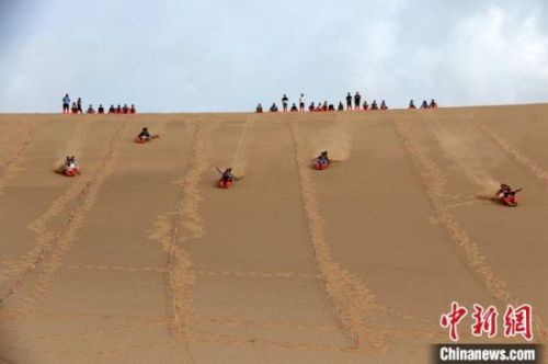 6月13日，敦煌鸣沙山月牙泉景区举办滑沙比赛。　张晓亮 摄