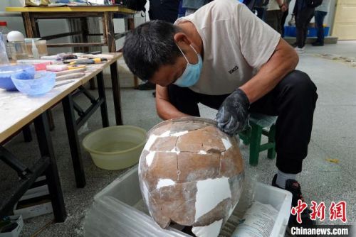 南佐遗址考古基地的整理室内，工作人员正在修复一件出土陶器。　<a target='_blank'  data-cke-saved-href='/' href='/'>中新社</a>记者 孙自法 摄
