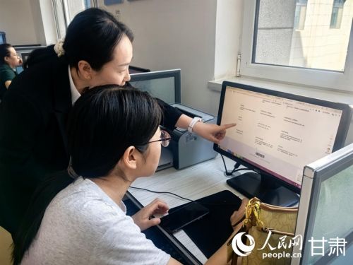 兰州新区政务服务大厅便民自助服务区工作人员协助企业负责人填写申报材料。人民网记者 周婉婷摄