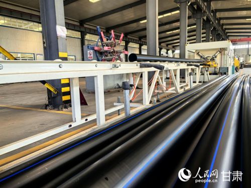 甘肃雨禾节水灌溉设备有限公司生产车间里,PE100给水管陆续下线。人民网记者 周婉婷摄