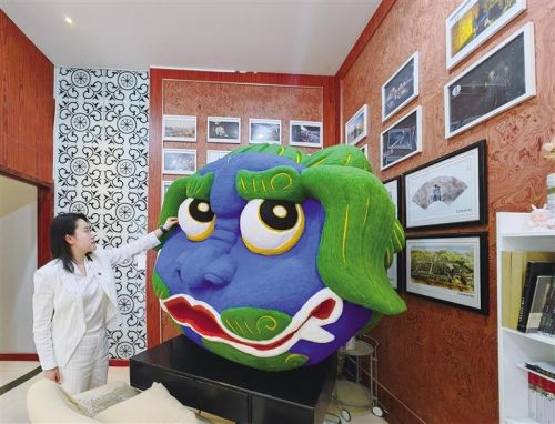 游客在市博物馆数字文创中心巨型“兰小五”毛毡作品前拍照打卡