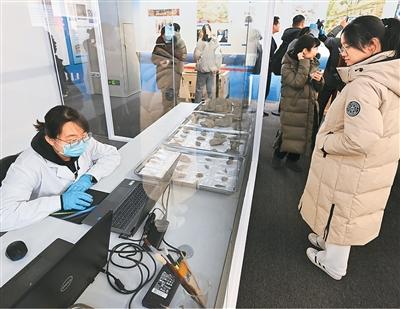 二〇二五年年初,“妙手活千秋——科技考古与遗产保护经典成就展”在位于北京的中国考古博物馆开展。图为参观者在展厅观看实验室考古展示区。新华社记者 李 贺摄