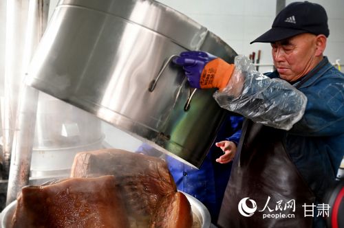 工作人员正用传统方法烹煮陇西腊肉，香气四溢。人民网记者 焦隆摄